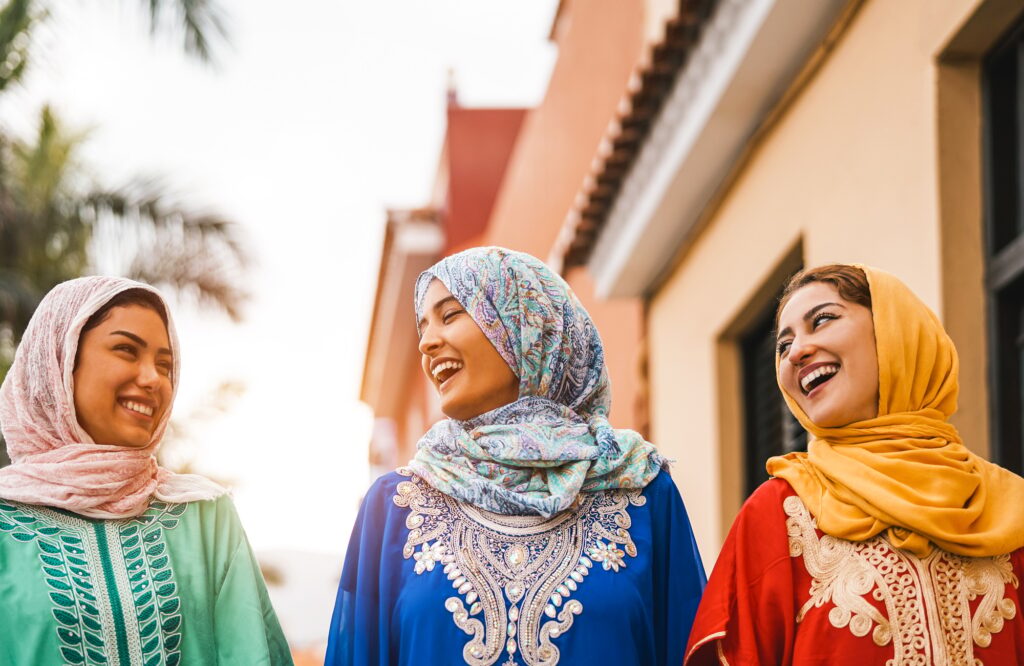 Happy Muslim women walking in the city center
